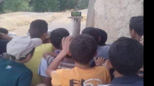 الصورة التي أشعلت فيسبوك ..أطفال مغاربة يتابعون مباراة المغرب كوت ديفوار على هاتف نقال!