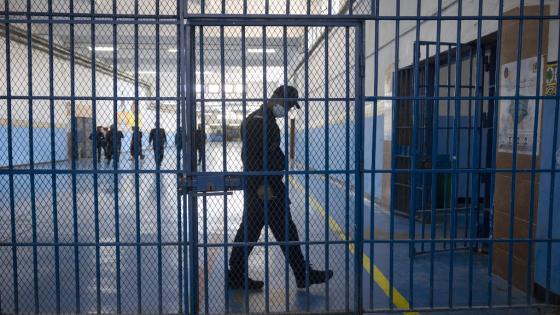 A guard walks behind one of the gates inside the prison of Kenitra, in the coastal city of the same name, near the Moroccan capital Rabat, on August 31, 2021. - After passing through the North African kingdom's Moussalaha ("Reconciliation") programme, some prisoners are hoping for a reprieve. The programme, launched in 2015 and led by Morocco's DGAPR prison service with several partner organisations, aims to help terror detainees who are willing to question their beliefs. (Photo by FADEL SENNA / AFP)
