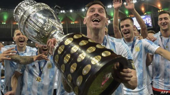 Argentina's Lionel Messi holds the trophy as he celebrates with teammates after winning the Conmebol 2021 Copa America football tournament final match against Brazil at Maracana Stadium in Rio de Janeiro, Brazil, on July 10, 2021. - Argentina won 1-0. (Photo by CARL DE SOUZA / AFP)